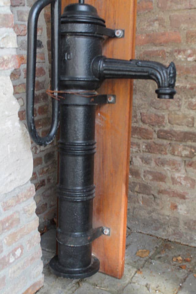 Zwarte-gelakte-waterpomp-op-houten-bord-compleet