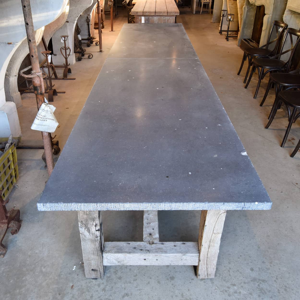 Unieke lange tafel eiken onderstel en Belgisch hardstenen blad